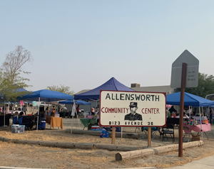 Photograph of an outdoor area at the Allensworth Community Center with blue pop-up tents.