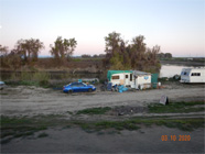 Opening in chain link fence along Smith Canal levee with debris covering the whole side of the levee - Date of 03.11.2020 shows at the bottom of the photo