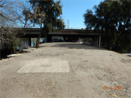 View of Smith canal levee under driving bridge showing homeless encampment tents and debris. - Date of 03.11.2020 shows at the bottom of the photo