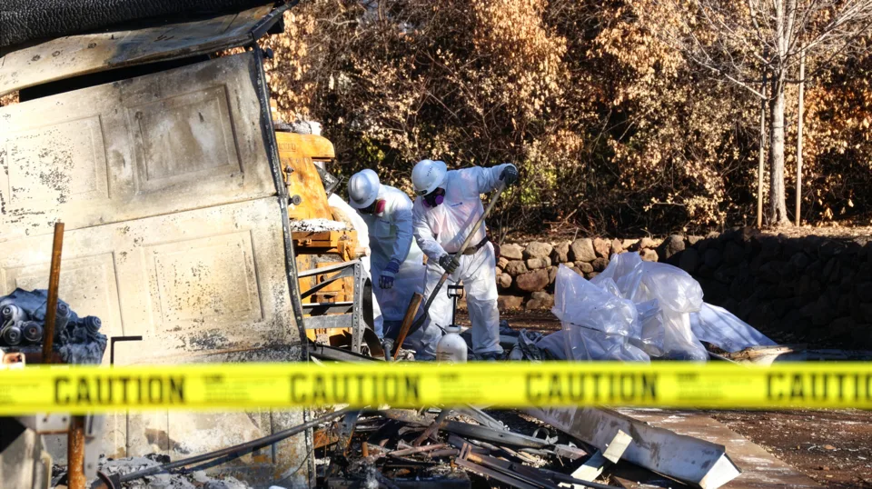 State contractors in hazardous protection gear clean up a destroyed home after the Camp Fire in Paradise, CA. Credit: CalRecycle