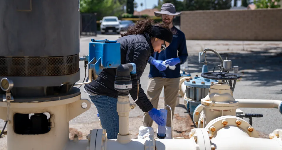 Two scientists taking water samples from a well in California